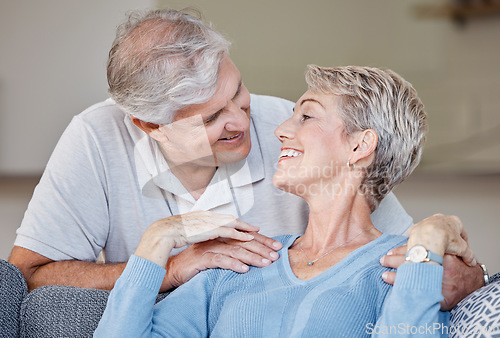 Image of Love, senior couple and relax on a sofa, smile and happy while sharing intimate moment, bond and romance in living room. Happy family, retirement and senior embrace on a couch, in love and relaxing