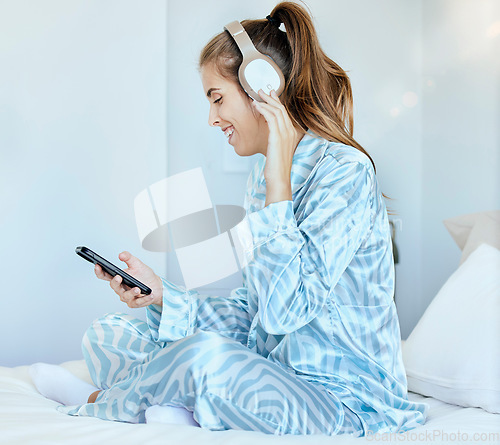 Image of Music, phone or woman on social media in bedroom laughing at funny memes or online content at home. Morning, relaxing or happy girl streaming a digital podcast, radio, song playlist while chatting