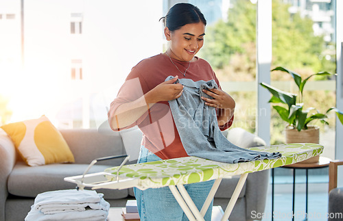 Image of Woman, laundry and ironing board, cleaning service and domestic worker with happy, smile and working in home. Happiness female, cleaner and housework with clothing, clothes and hygiene in house