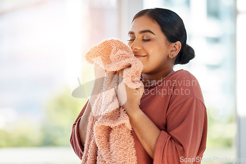 Image of Woman smelling clean laundry, blanket or fabric for fresh and clean smell in house after doing washing, cleaning and housekeeping. Happy female cleaner with textile for aroma, fragrance and scent
