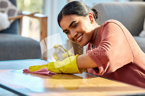 Image of Woman, wipe table and spray with cloth, for hygiene and disinfectant in home. Cleaner, maid or female cleaning service for bacteria, dust on furniture and housekeeping with rag, surface and detergent