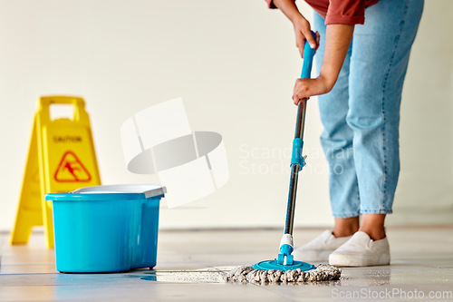 Image of Cleaning, sign and woman mopping floor in office for hygiene, health and wellness. Spring cleaning, service and janitor, cleaner and female with mop, water bucket and caution wet floor warning notice