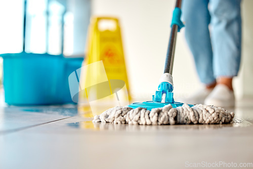 Image of Mop, cleaner and washing wet floor for hygiene, disinfection or sanitary area for cleanliness at the workplace. Housekeeper cleaning dirty flooring for sanitization, water or wash indoors