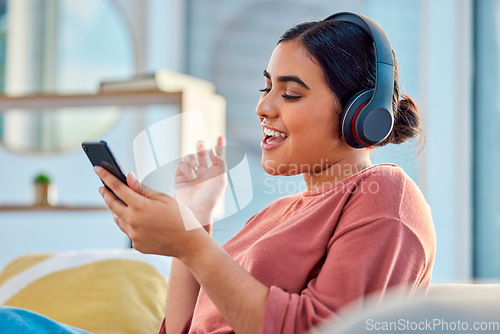 Image of Woman on couch, smartphone and headphones for music, audio and connectivity in lounge. Hispanic female, girl and headset for radio, podcast and streaming to listen, social media, connect or happiness