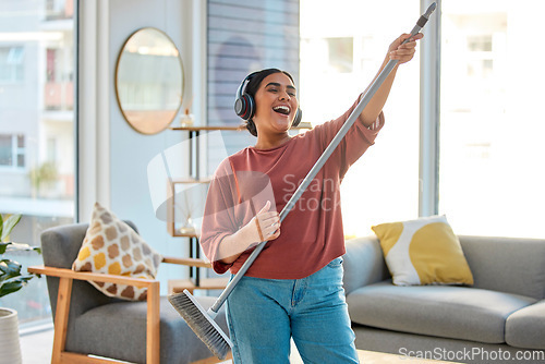 Image of Dance, radio or woman cleaning with music for singing or listening to a song with broom as a guitar at home. Relax, freedom or happy Indian girl cleaner streaming audio on headphones or housekeeping