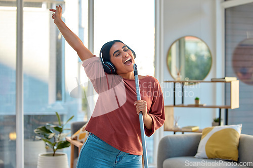 Image of Cleaning, singing and woman dance to music for fun, energy and happiness while doing housekeeping, mop and broom in living room. Spring cleaning, headphones and happy dancing at home with freedom