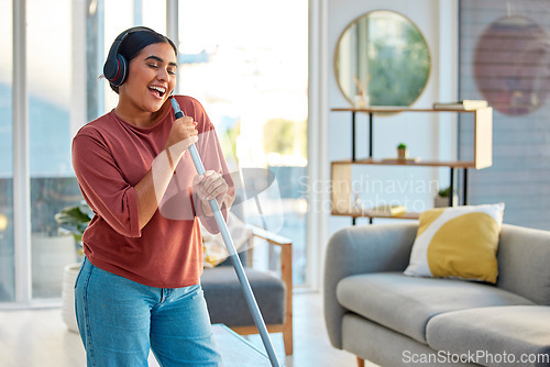 Image of Singing, cleaning and headphones of a woman with music working in a home dancing with happiness. Spring cleaning, cleaner and happy person sing and dance with a mop in living room listening to audio