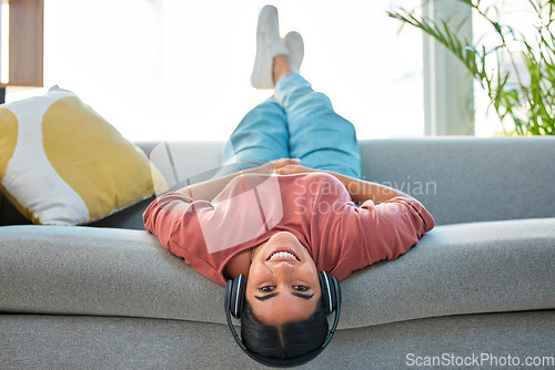 Image of Woman, sofa and relax with headphones, music and smile in portrait while upside down in lounge. Happy lady, couch and lying for happiness, streaming podcast or web radio in home living room in Mexico