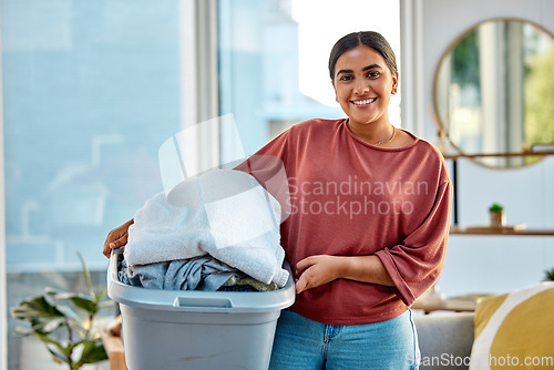 Image of Woman, laundry and portrait smile for clean clothes, personal hygiene or housework at home. Happy female holding washing basket of material for cleaning, chores or housekeeping in the living room