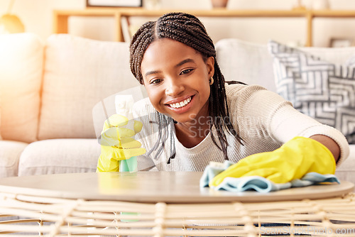 Image of Smile, spray bottle and black woman cleaning table with gloves and alcohol solution in living room. Coffee table, spring cleaning and happy woman wiping dust in home for safety from bacteria and germ