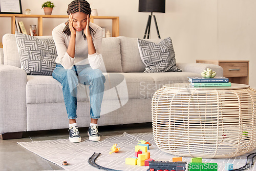 Image of Black woman, headache and mental health, stress and anxiety while depressed on sofa in home living room. Stressed female, mistake and sad, head pain and tired of burnout problems on couch in home