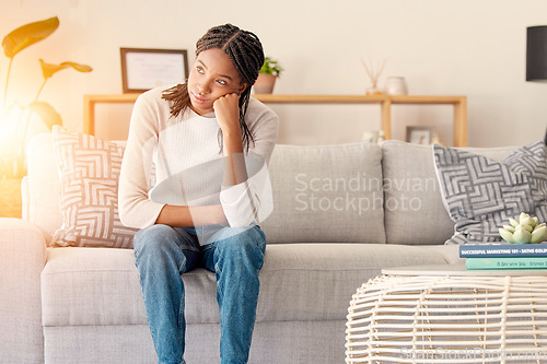 Image of Stress, thinking or burnout black woman in living room. of house or home with sun lens flare light on sofa. Focus, sunshine or girl sitting on lounge couch with depression, anxiety or mental health