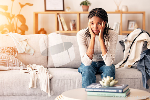 Image of Sad, thinking and black woman with depression on sofa in home. Mental health, anxiety and female from Nigeria on couch contemplating rent, student loans or life problems, mistake or stress in house.