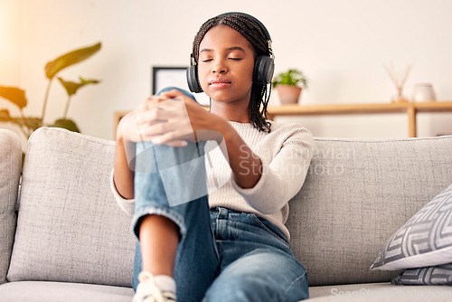 Image of Music headphones, peace and relax girl listening to wellness podcast for calm mindset, mindfulness or audio meditation. Easy meditating, living room sofa or gen z black woman streaming zen radio song