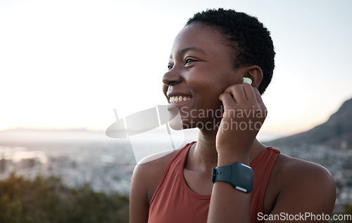 Image of Earphones, music and fitness with a sports black woman in nature for exercise or a cardio workout. Training, thinking and running with a female athlete streaming audio while endurance exercising