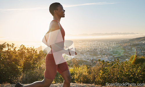 Image of Fitness, sunset and profile of running black woman training for USA marathon race, cardio workout or body health goals. Blue sky flare, nature and runner exercise in Los Angeles Hollywood mountains