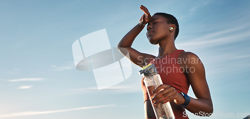 Image of Water bottle, tired and black woman on break after running, exercise or cardio workout with low angle and mock up. Sports, fitness and sweating female holding liquid for hydration after training.