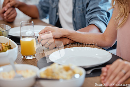 Image of Holding hands, praying and food with a family grace around the dinner table during a thanksgiving celebration. Prayer, trust and love with a group of people enjoying lunch during a social gathering