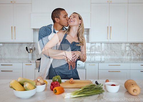 Image of Couple, cooking food and love of vegetables with a kiss on the cheek while helping with dinner at home. Man and woman in Uk with a healthy lifestyle, diet and vegan eating for health and wellness