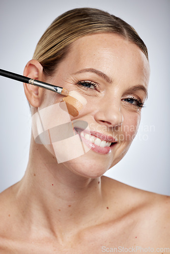 Image of Portrait, beauty woman and foundation color for skincare or cosmetics dermatology and facial wellness in studio. Happy model, apply luxury makeup and face products or glowing skin with brush