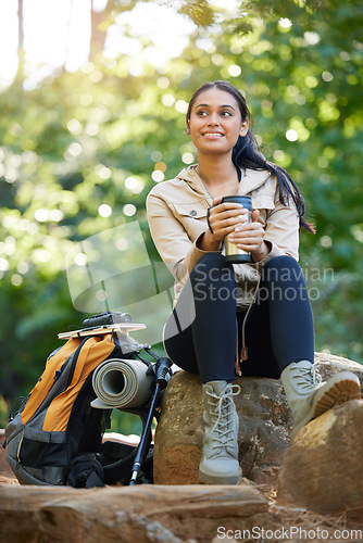 Image of Nature, relax and hiking woman drinking coffee on rock on adventure trail with trees. Health, fitness and freedom, happy woman in forest or jungle in Brazil sitting on rocks with smile and backpack.