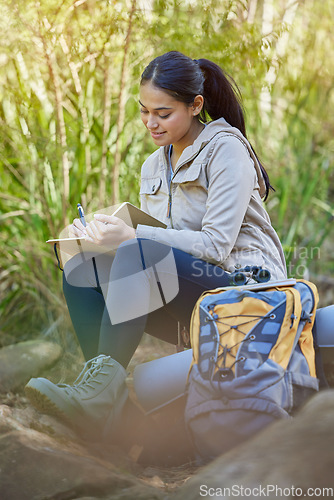 Image of Hiking, travel and woman writing in book sitting outdoors in nature. Freedom, hiker and happy female from India with personal diary, notebook or journal to write ideas, thoughts or journey experience