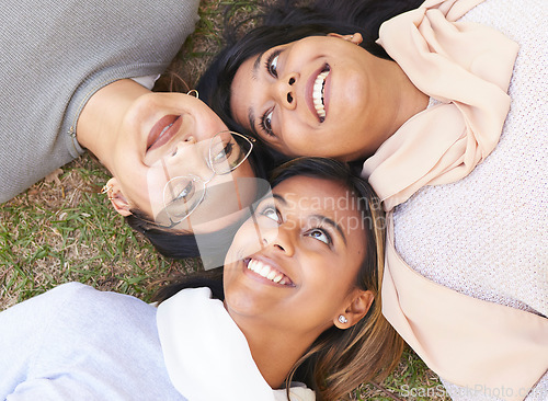 Image of Faces, group and women lying on the ground in a park for cheerful bonding with love and care. Friendship, overhead and female hangout in a garden outdoors for bond and relationship in nature