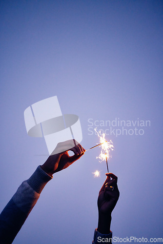 Image of Sparkler, fire and hands of a person on a blue sky, celebration with light and outdoor party at night. Creative, color and woman with fireworks to celebrate in nature during sunset at new years