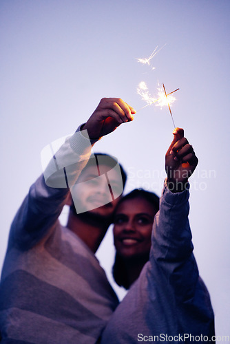 Image of Couple, sparklers and happy together for night celebration or romance date for love, support and freedom outdoor. Smile, Indian woman and man hugging or quality time to celebrate happiness in Bali