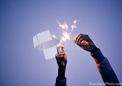 Image of Sparkler, hand and person at night for new years eve celebration with bright, burning fun to celebrate. Celebrating, sparkle and blue nighttime background with a firework or firecracker in hands