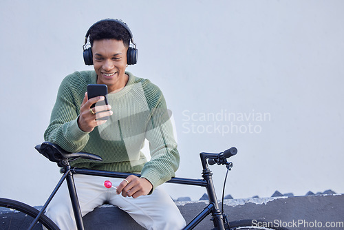 Image of Black man, bicycle and headphones for travel, social media update and 5g networking on nature or sky mockup for marketing. Student bike, music streaming service and smartphone with advertising space