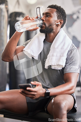 Image of Water bottle, black man in gym and smartphone for social media after fitness exercise, healthy sports workout and muscle growth. Wellness work out, training motivation and a tired guy drinking water