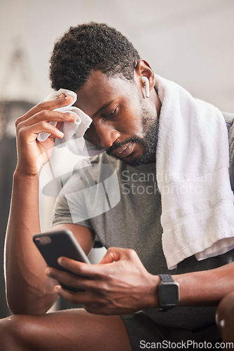 Image of Black man, phone and sweat for relax fitness or typing sports communication online, exercise training and runner workout. Cardio wellness, run motivation rest or athlete reading on smartphone in gym