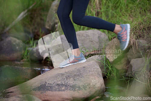 Image of Fitness, legs or shoes running in nature for training, cardio exercise or workout by a river, water or lake in Amsterdam. Footwear, sneakers or healthy sports girl runner in running shoes on a rock