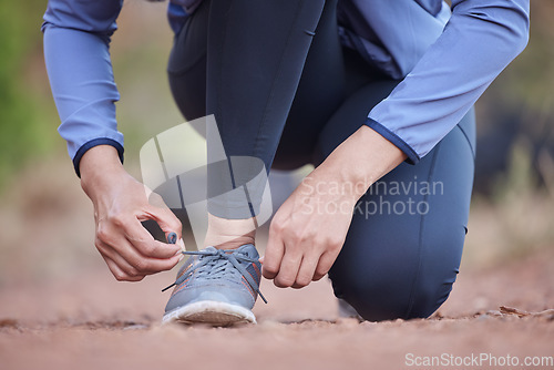 Image of Fitness, hands and running shoes in preparation for exercise, training or cardio workout in the nature outdoors. Hand of runner tying shoe laces getting ready for run, healthy exercising or trekking