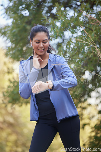 Image of Fitness, runner heart rate and woman watch run time in nature park doing sports and workout. Exercise, wellness and running training of an athlete checking digital smartwatch for performance