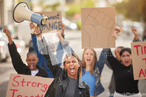 Image of Woman, megaphone and fist in community protest for equality, human rights or economic change in the city. Angry women standing together marching in the street for strike, voice or billboard message