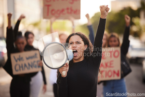 Image of Woman, megaphone and fist in community protest for change, gender based violence or equality in the city. Angry women activist standing together in march strike for human rights or government action