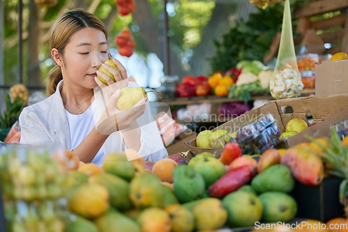 Image of Fruits, food and woman in Japan market for quality choice, nutrition and healthy shopping in green, eco friendly store. Outdoor marketplace, pear and vegan asian or customer sale, offer and discount