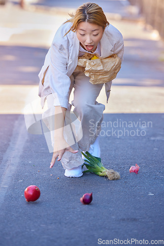 Image of Drop, accident and woman with groceries in the street, clumsy and trip while walking with shopping bag in the city of Japan. Falling, tripping and wow of an Asian girl with grocery food in the road
