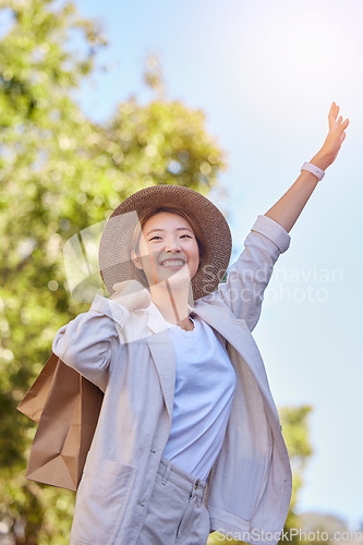 Image of Asian woman, shopping bag and stop taxi in city outdoor after buying clothing in town. Travel, sales deals and happy female from Japan holding gifts after shopping on Black Friday for cheap discount.