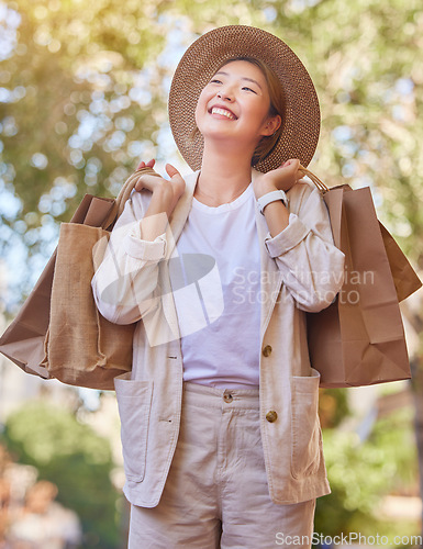Image of Grocery shopping, happy and woman in the city for groceries, thinking of sale and food discount in Singapore. Retail smile, shopping bag and Asian person with an idea for products from a supermarket