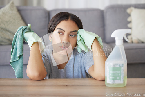 Image of Tired, woman in home or spray bottle with cloth, mental health or exhausted with cleaning. Hispanic female, cleaner and sad maid in living room, rag or disinfectant with depression, stress or anxiety