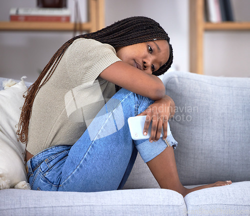 Image of Breakup depression, sad and thinking black woman with a phone after communication, problem and anxiety about email on the couch. Mental health, idea and African girl depressed about chat fail
