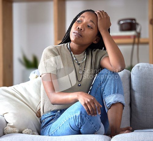 Image of Black woman, sofa and stress with worry, thinking and sad in home living room with fear of future. African woman, sitting and lounge couch with anxiety, depression or mental health problem in Chicago