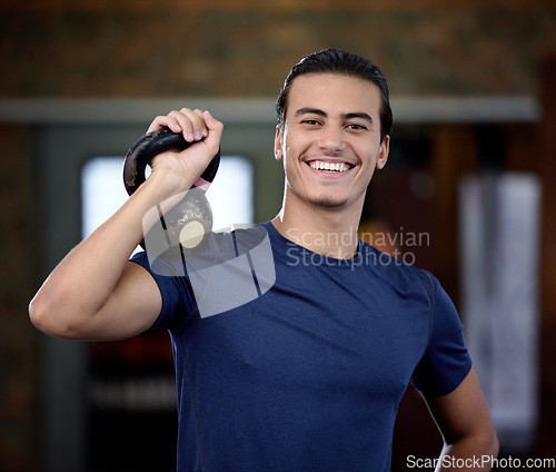 Image of Fitness, portrait or man at gym with a kettlebell for strong arms or training biceps in workout or weightlifting exercise. Smile, face or happy personal trainer ready for coaching with wellness goals