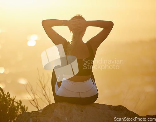 Image of Relax, sunset and fitness woman on a mountain rock looking at nature view for calm yoga. Workout, zen and back of a pilates athlete with peace, meditation and chakra wellness training outdoor