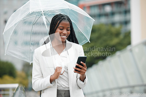 Image of Business, black woman and smartphone, city and rain with umbrella, insurance with communication and technology. Professional, urban and commute to work, online with smile and female worker in Chicago