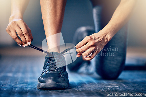 Image of Fitness, gym and man tie shoes ready to start exercise, bodybuilder workout and training in sports center. Performance, motivation and hands tying sneakers for healthy lifestyle, wellness and cardio