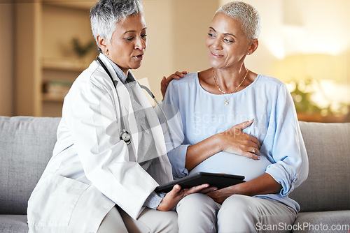 Image of Pregnant, woman and senior ivf doctor on tablet for planning, results and discussion on sofa during home checkup. Healthcare, pregnancy and consulting with mature doc while checking online plan